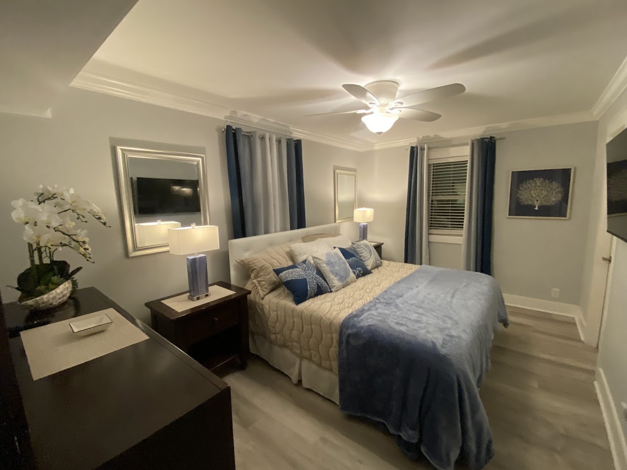 A cozy bedroom with a plush bed covered in beige and blue linens