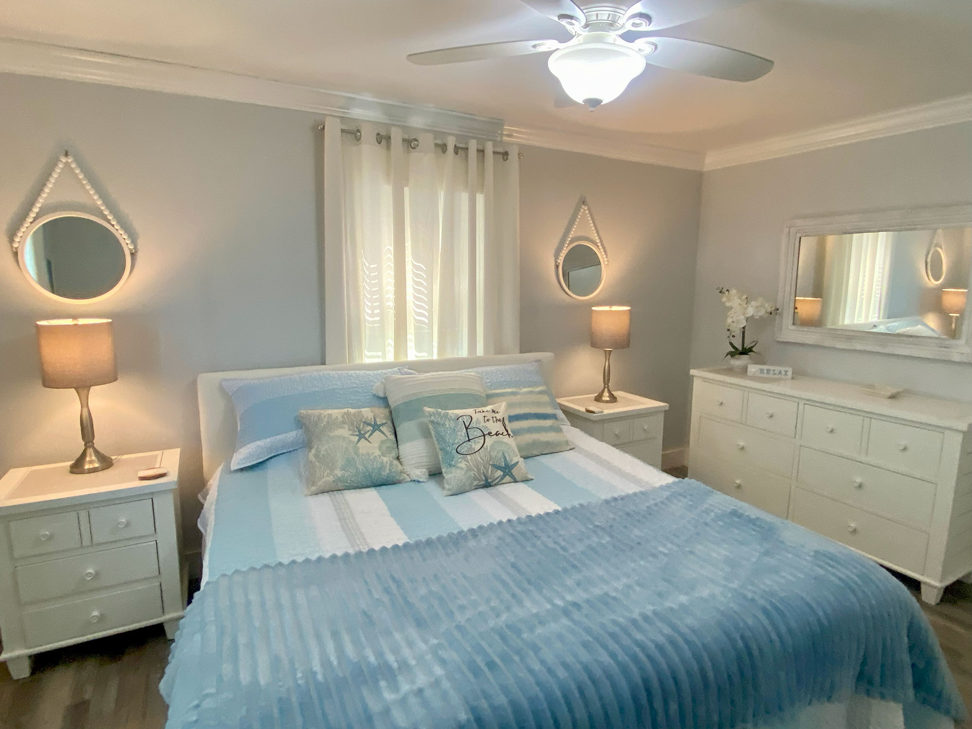 A cozy bedroom with a light blue and white color scheme